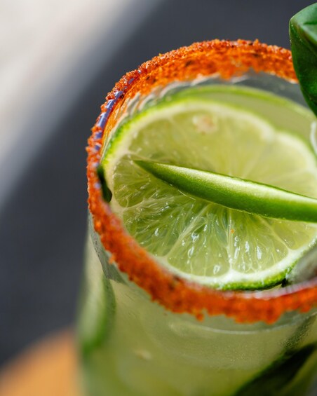 A close-up of a lime slice in a glass with a salted rim. 3