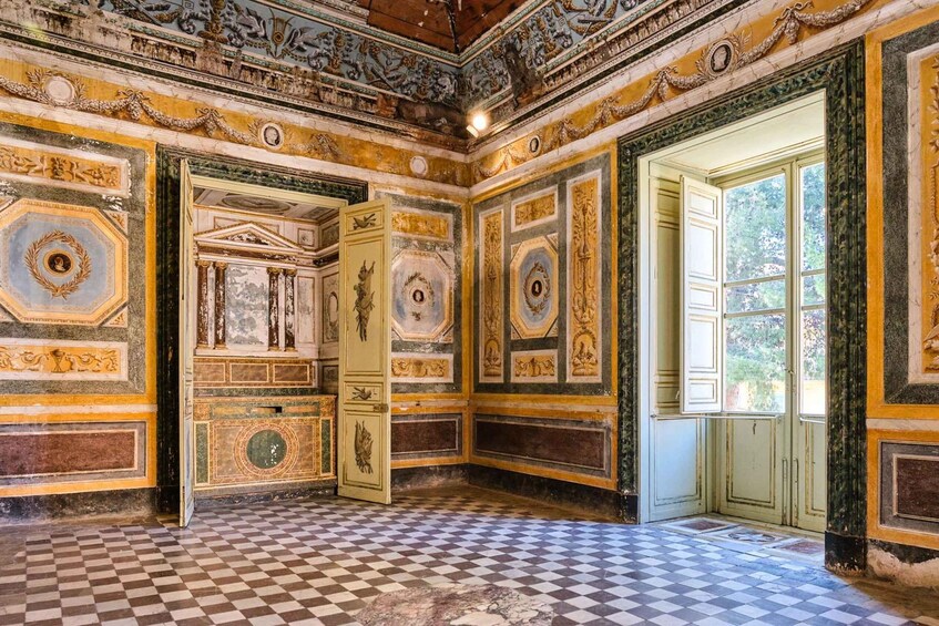 An ornate room with checkered flooring, detailed frescoes, and classical architectural elements. 5