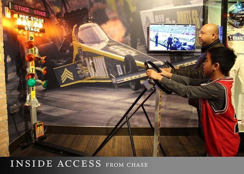 A person playing a racing video game with a car model on a stand. 3