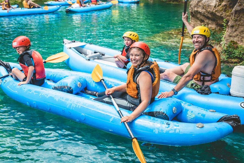 People in blue inflatable rafts on a calm river. 2