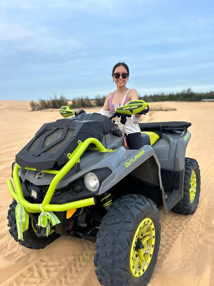 A person on a yellow and black ATV in a desert. 3