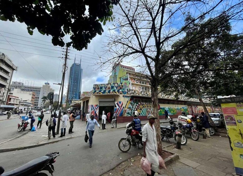 A busy urban street with pedestrians, motorcycles, and colorful buildings. 2
