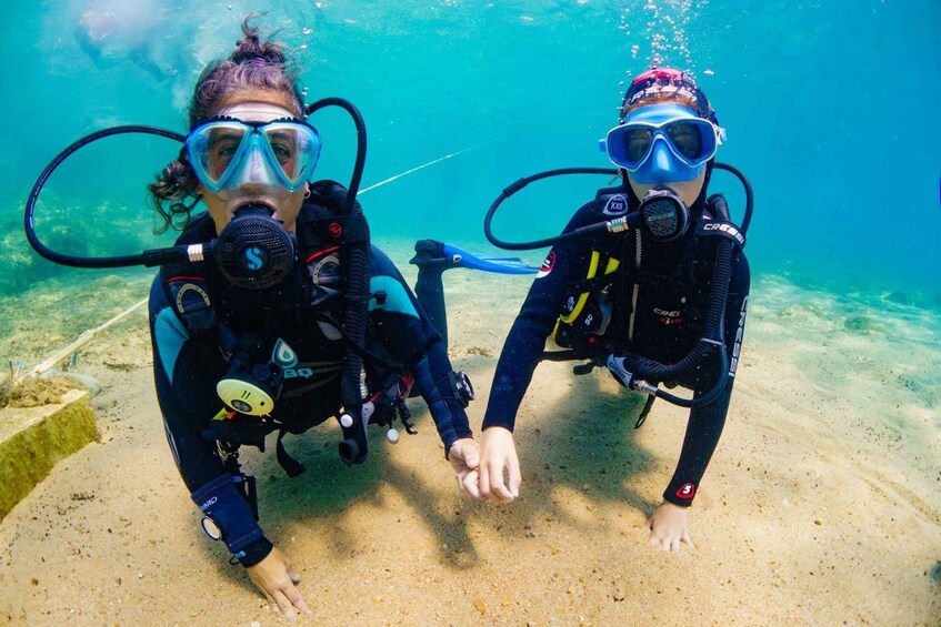 Two scuba divers underwater, one with a snorkel and the other with a regulator. 1