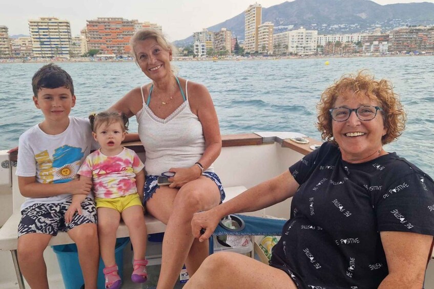 A family on a boat with a cityscape and mountains in the background. 4