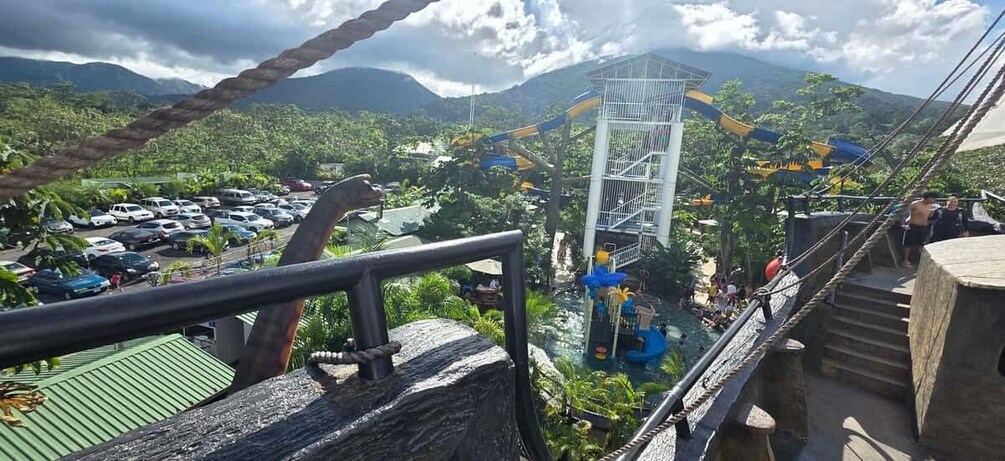 A water park with a water slide, a parking lot, and a mountainous landscape in the background. 3