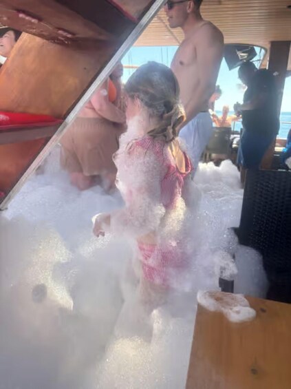 A child playing in a large amount of foam on a boat. 1
