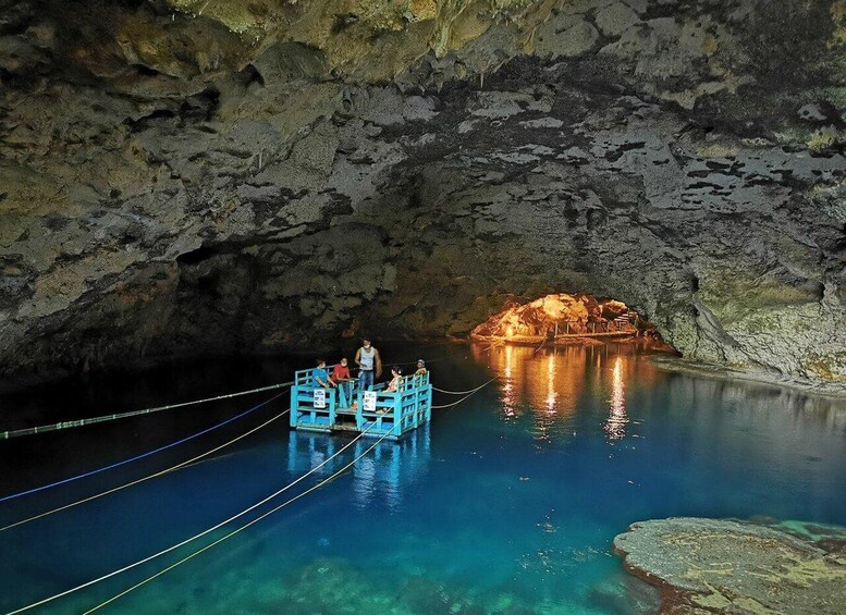A cave with a boat in the water and a cave opening. 2