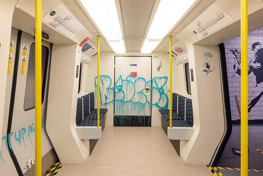 A subway car interior with graffiti, yellow poles, and a door marked 22428. 4
