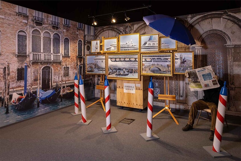 A maritime-themed exhibit with framed pictures, a gondola display, and a service counter. 5