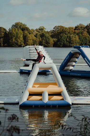 A person on a floating platform with inflatable structures in a body of water. 1