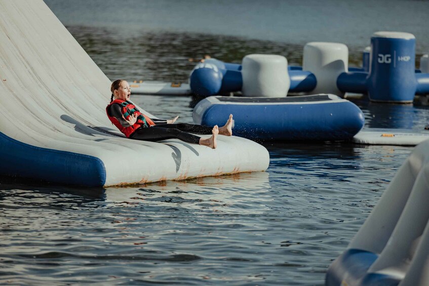 A person on a water slide with inflatable tubes and water. 4