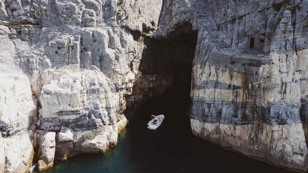 A boat in a rocky canyon with water at the base. 5