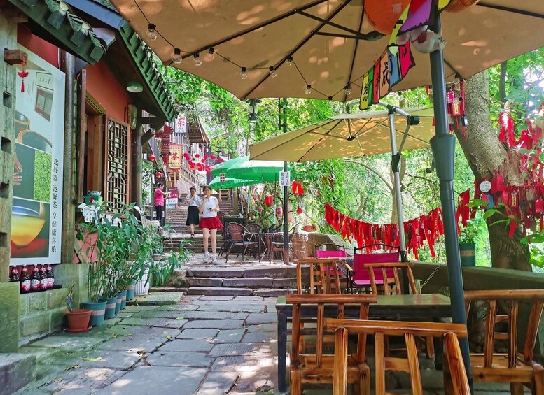 A traditional outdoor café with wooden furniture, a green umbrella, and red decorations. 5