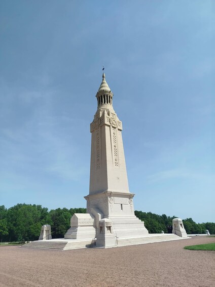A tall, white monument with a pointed top and a base with steps. 2