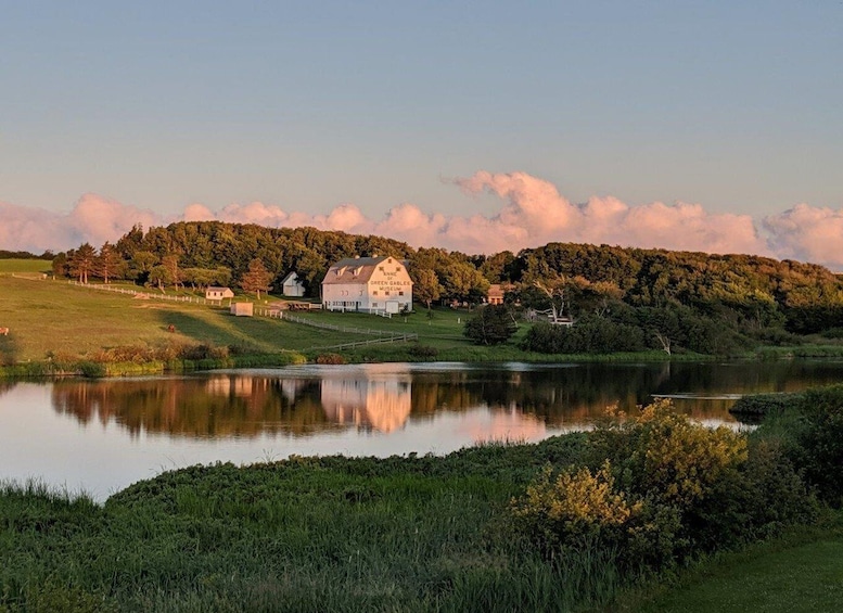 A serene landscape with a lake, a barn, and a museum labeled 'Anne Green Gable Museum' amidst lush greenery and trees. 3