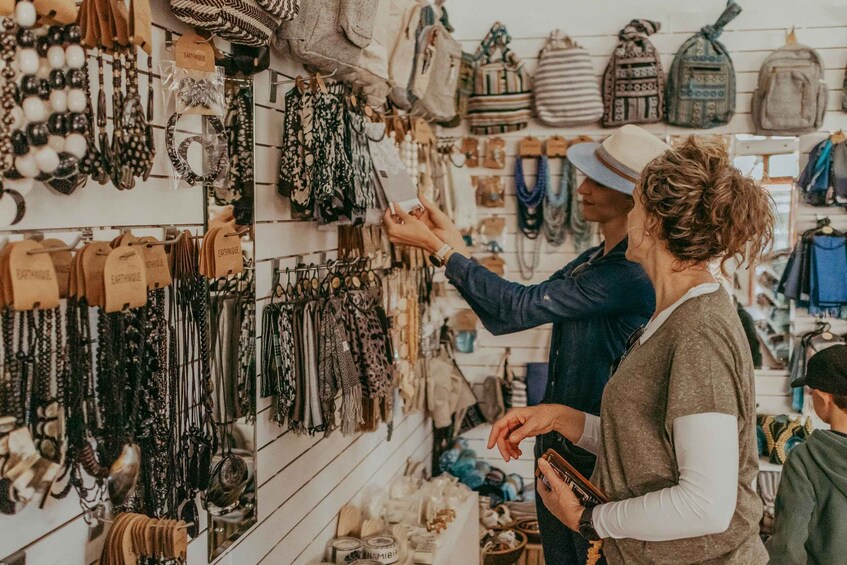 A person browsing through a variety of necklaces and bags in a store. 2
