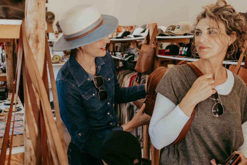 Two people in a clothing store, one holding a hat. 3