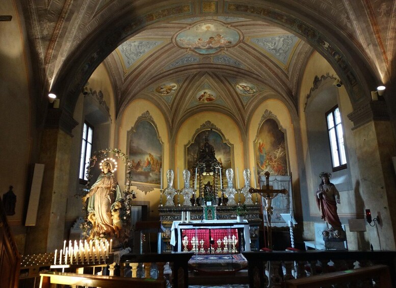 An ornate church interior with a central altar, statues, and a vaulted ceiling. 5