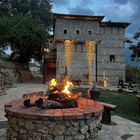 A stone building with a fire pit in front. 3