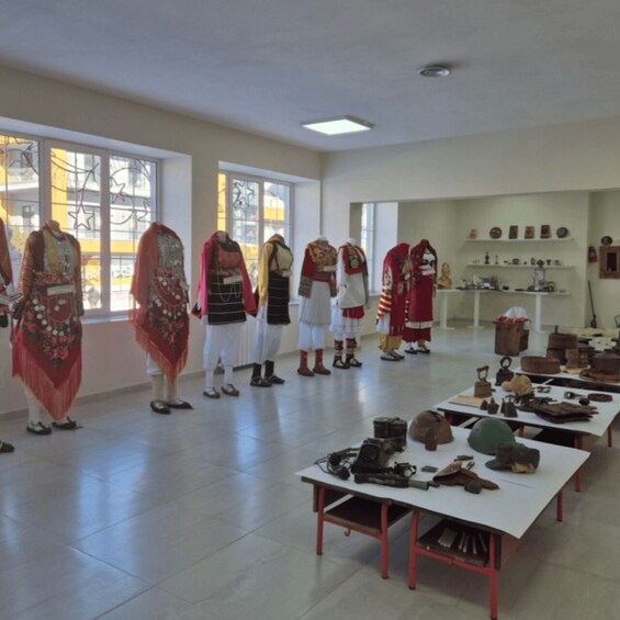 Mannequins in traditional attire, a table with historical artifacts, and a display of pottery. 4
