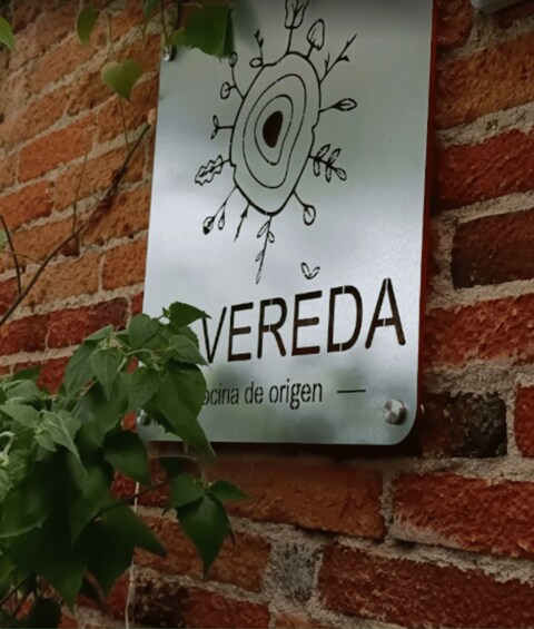 A sign with a tree drawing and the word 'VEREDA' on a brick wall. 4