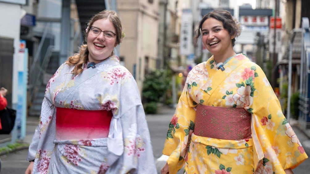 Two individuals in traditional Japanese kimonos walking on a city street. 1