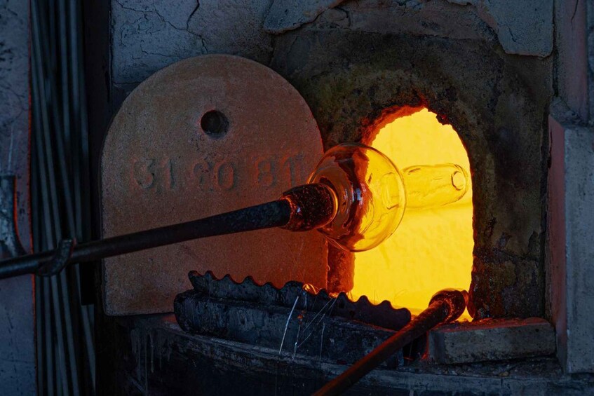 A glassblowing furnace with a glass piece being shaped. 5