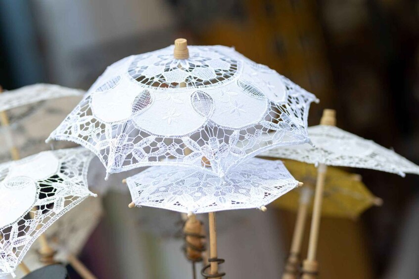 A collection of white lace umbrellas with wooden handles. 4