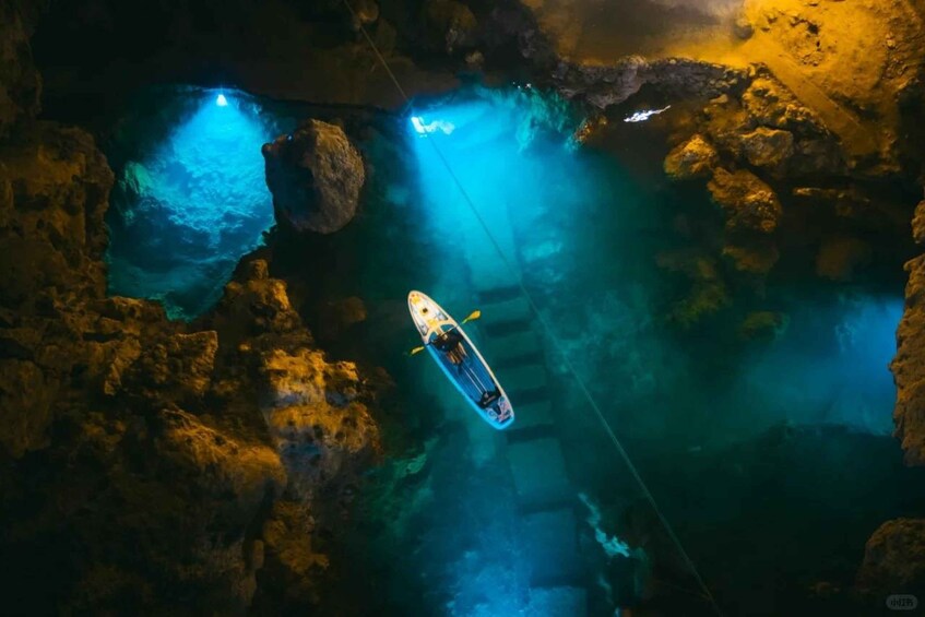 A kayak navigating through a cave with blue lighting. 1