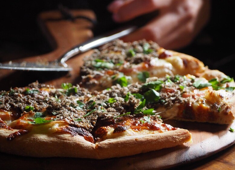 A pizza with toppings on a wooden board. 4