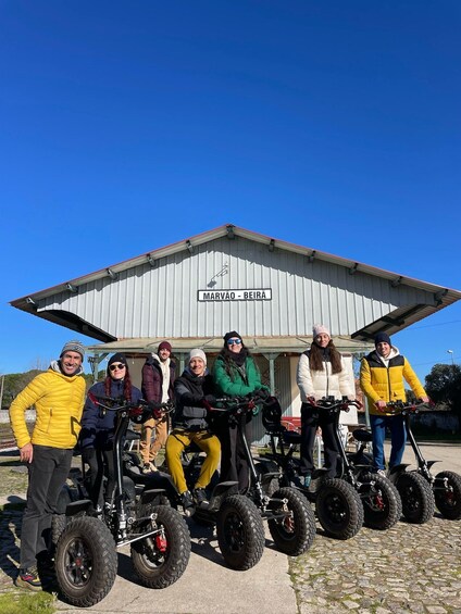A group of people on electric scooters in front of a building labeled 'MARVAO - BEIRA.' 5