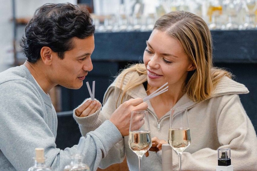 Two people sitting at a table with wine glasses and a bottle. 2