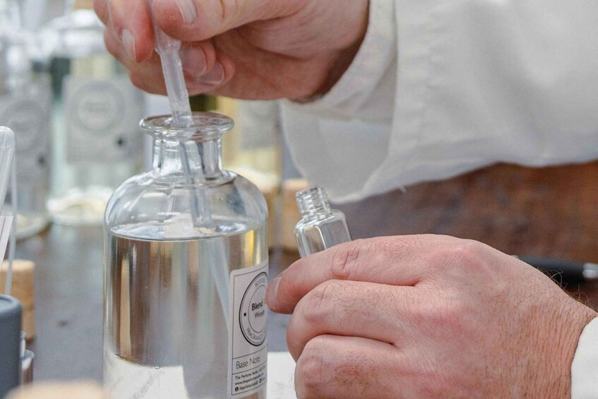 A person handling a glass bottle with a label, in a laboratory setting. 3
