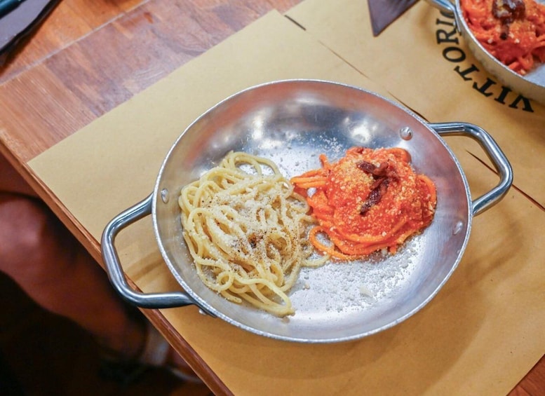 A stainless steel pan with spaghetti and a tomato-based sauce on a wooden table. 5