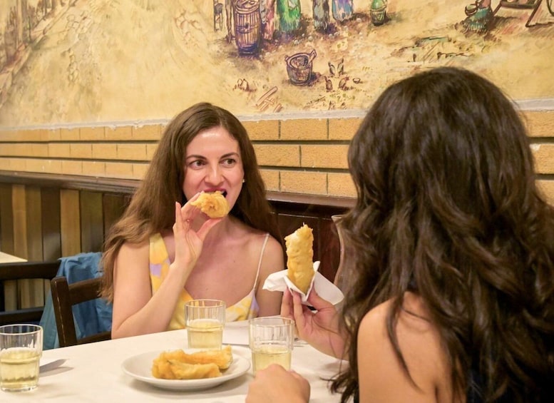 Two people dining at a restaurant with a mural in the background. 4