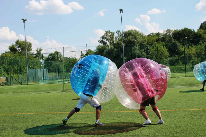 People playing with large inflatable balls on a sports field. 4