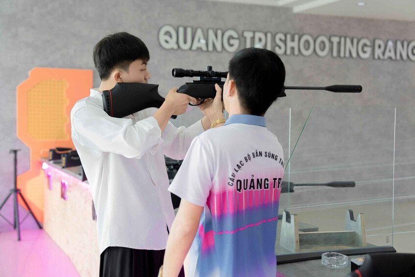 A person aiming a rifle at a target. 2