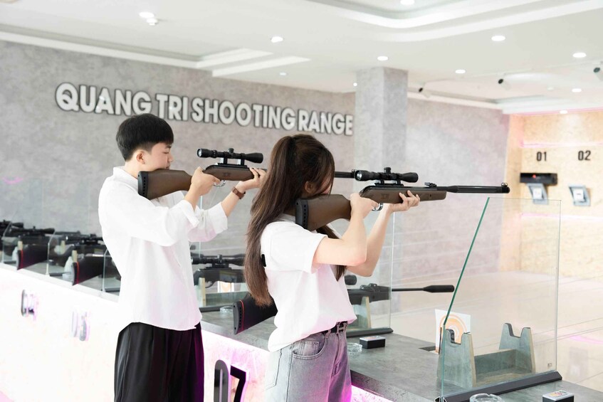 Two people aiming rifles at a shooting range. 5