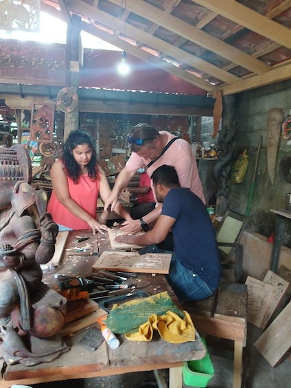 A workshop with individuals engaged in crafting wooden sculptures. 2