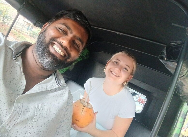 Two people inside a vehicle, one holding a drink. 3