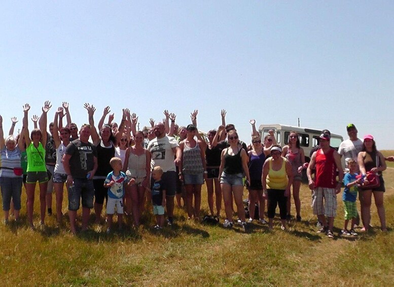 A group of people standing in a grassy field with their hands raised. 5