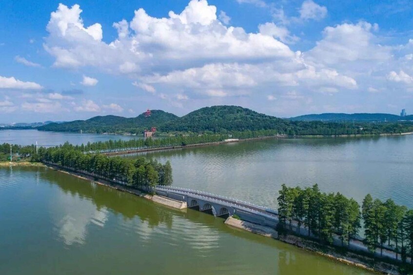 A river with a bridge, trees, and hills in the background. 4