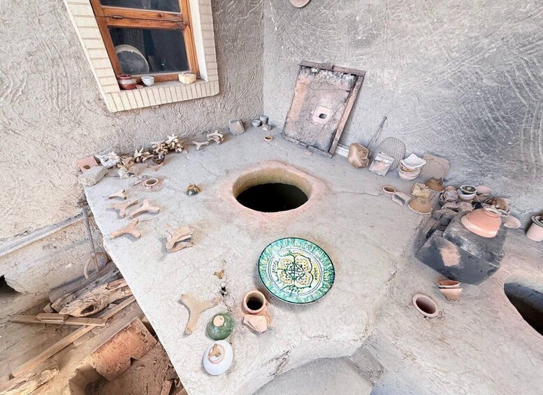 A traditional pottery workshop with a large clay oven, various pottery tools, and unfinished clay pieces. 4