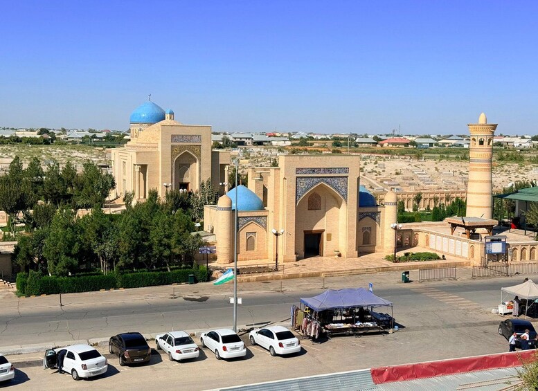A mosque with blue domes and a minaret, surrounded by a parking lot and a clear sky. 5