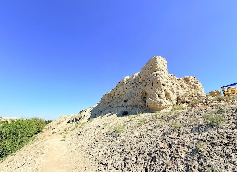 A rocky hill with a prominent rock formation and sparse vegetation. 4