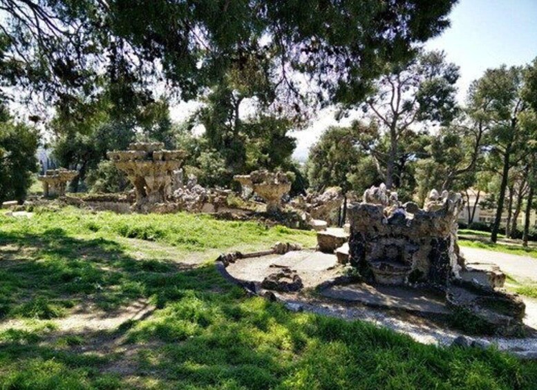 Ancient ruins with stone structures and trees in a park setting. 3