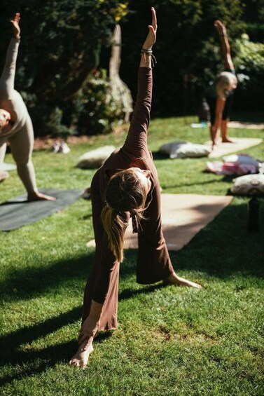 A person performing a yoga pose outdoors on grass. 1