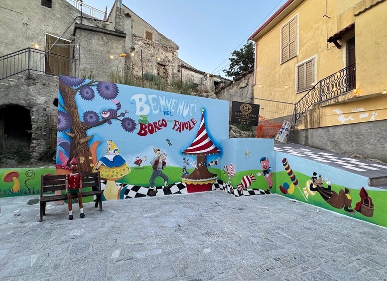 A colorful mural with characters from 'Bingo Bongo' and 'The Wizard of Oz' in a street setting. 1