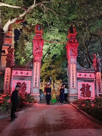 A traditional gate with red lighting, surrounded by trees and featuring Chinese characters. 3