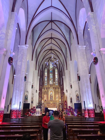 A cathedral interior with high arched ceilings, stained glass windows, and religious statues. 5